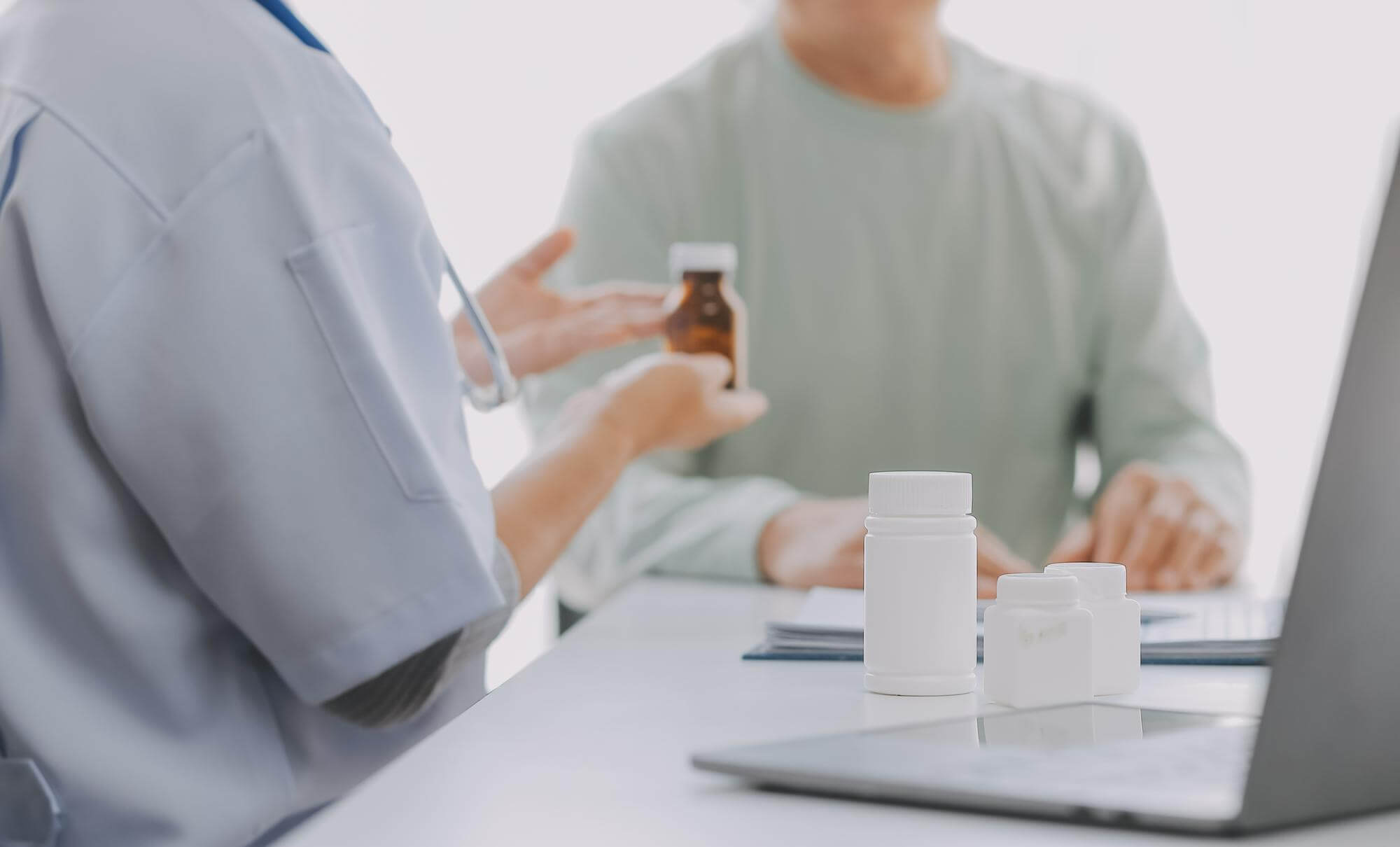 Ein Arzt übergibt einem Patienten ein Medikament in einer Arztpraxis.